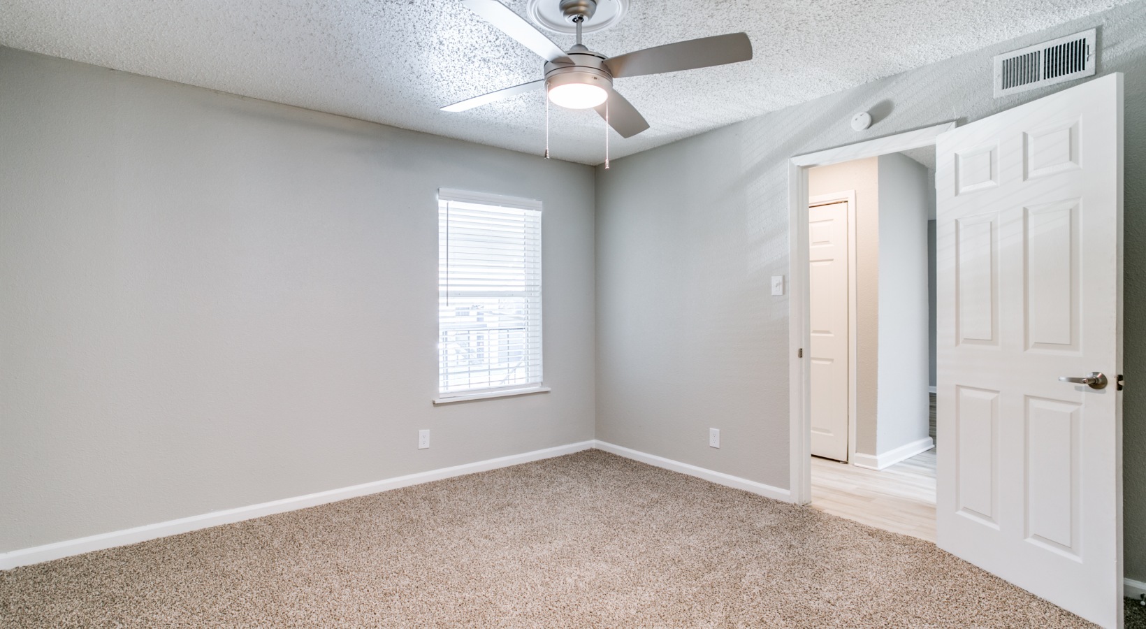 empty room with ceiling fan and carpet at The  Holden