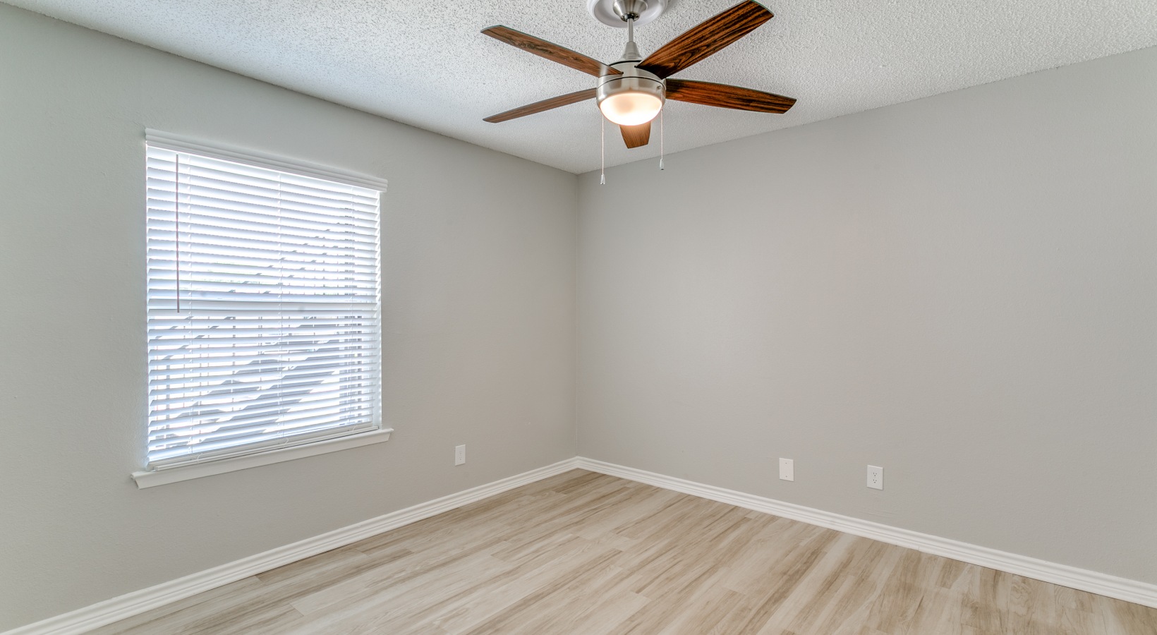 empty room with ceiling fan and hardwood floor at The  Holden