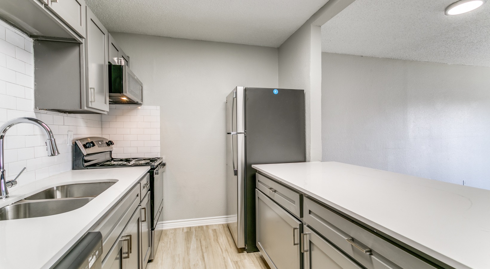 a kitchen with stainless steel appliances and white cabinets at The  Holden
