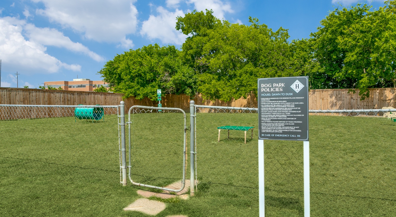 a dog park with a fence and a sign at The  Holden